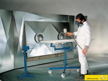 Bild zeigt einen Lackierer vor einer GESCHA Farbnebelabsaugwand Spritzwand Spritznebelabsauganlage. Die Anlage wird z.B. im Lackierraum, einem Spritzplatz oder Lackierkabine eingesetzt.